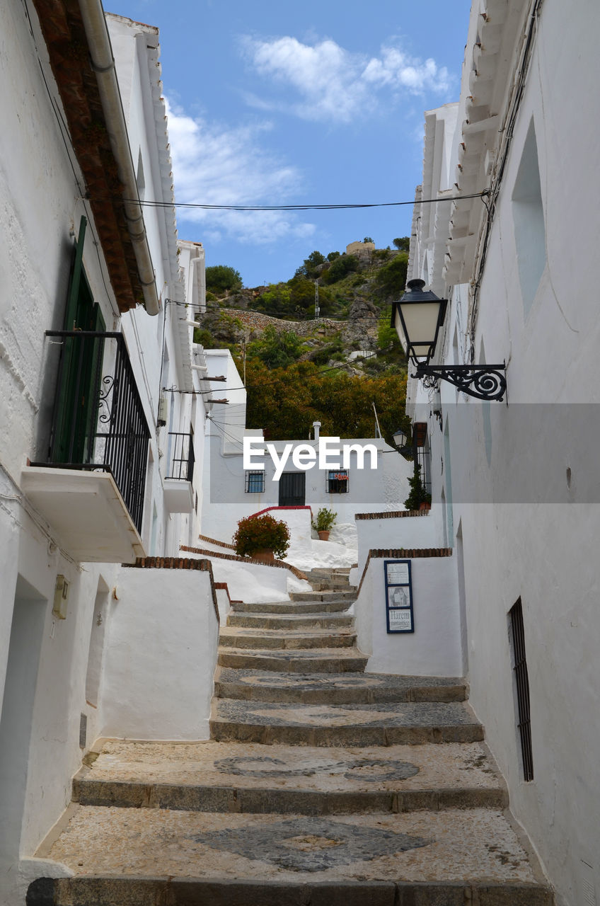 Low angle view of staircase amidst buildings against sky