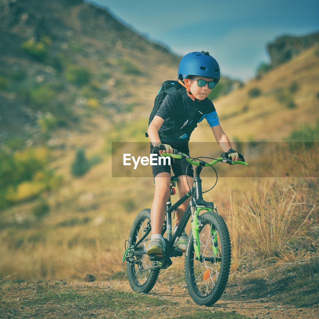 BOY RIDING MOTORCYCLE ON FIELD