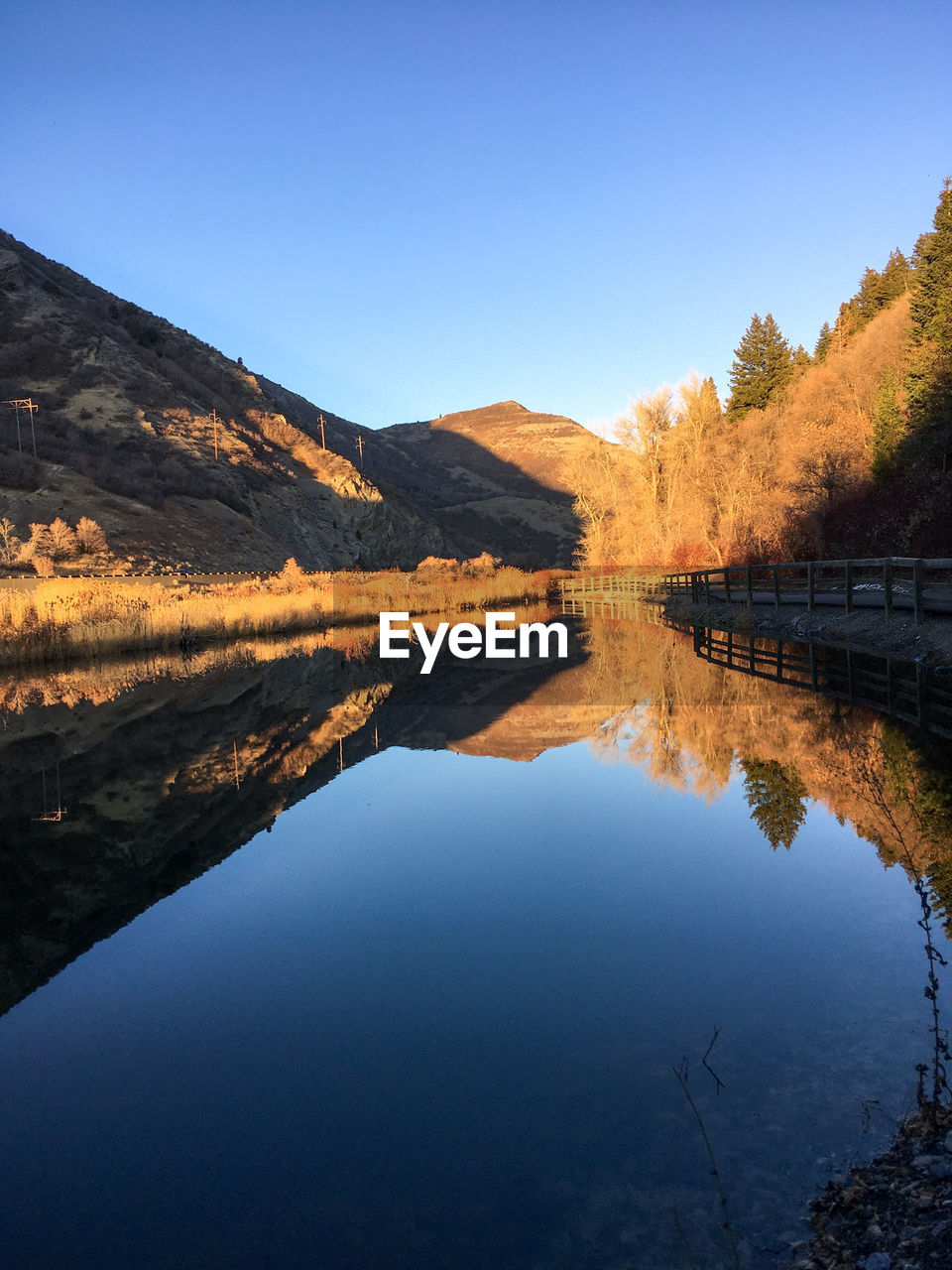 Scenic view of lake against clear blue sky