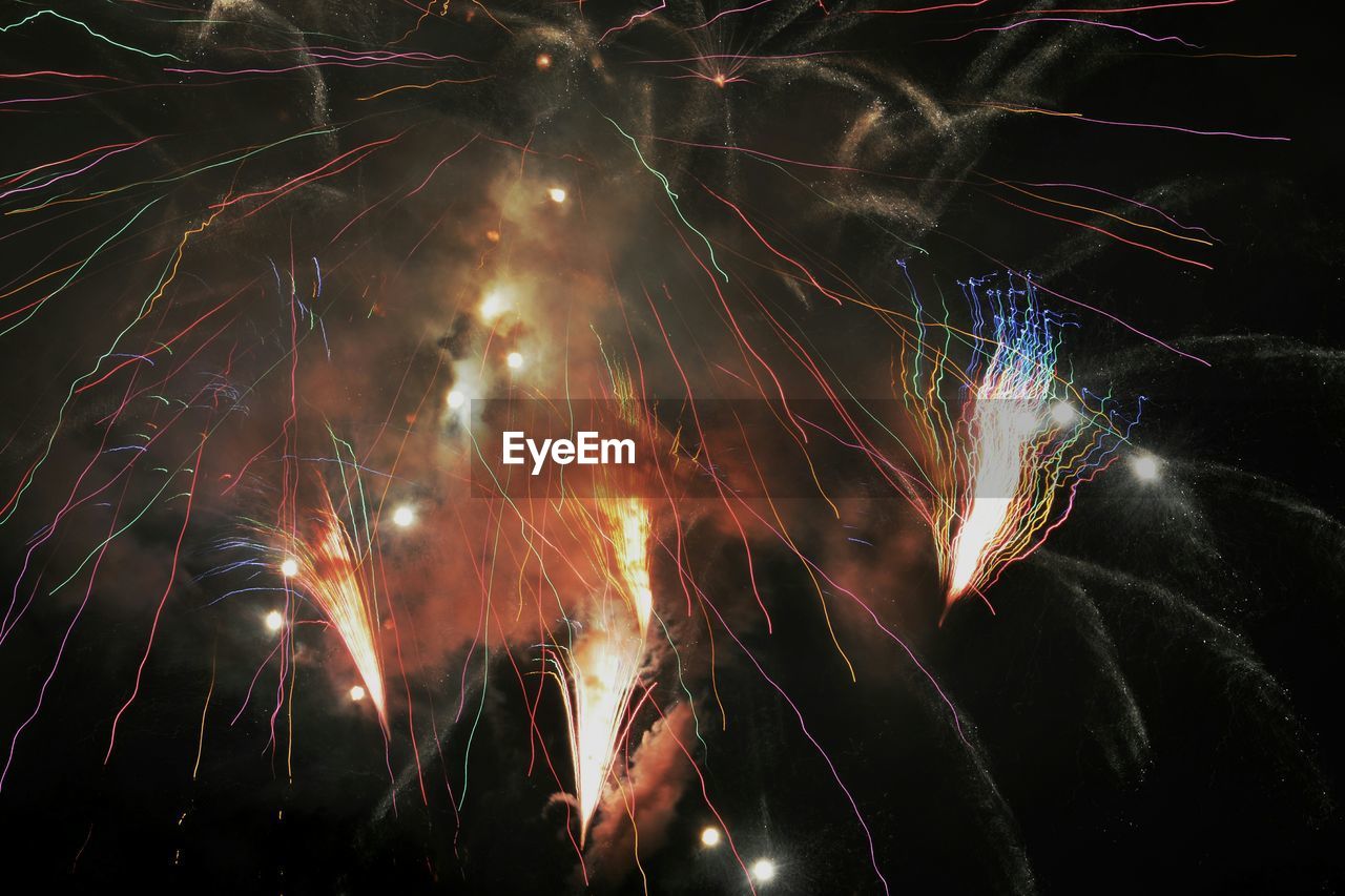 Low angle view of fireworks against sky at night