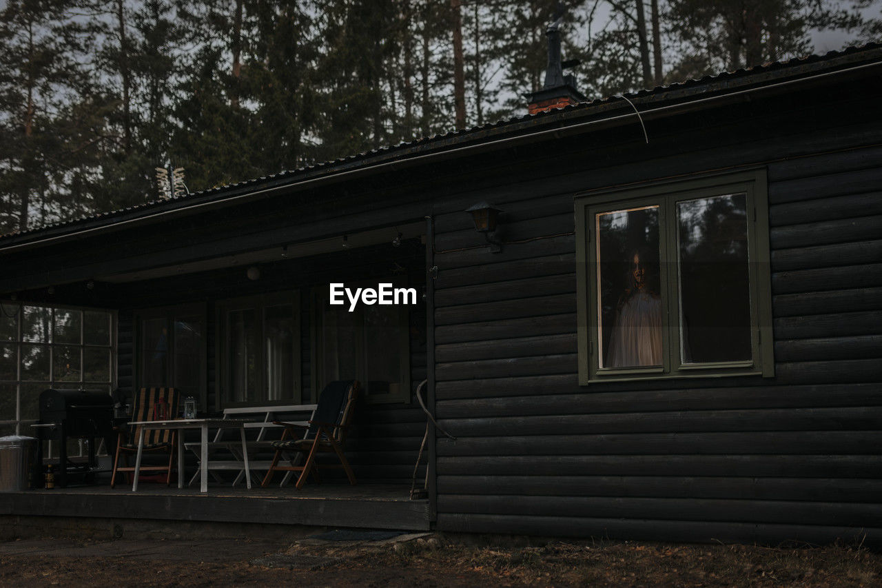 Female ghost seen through window of haunted cabin