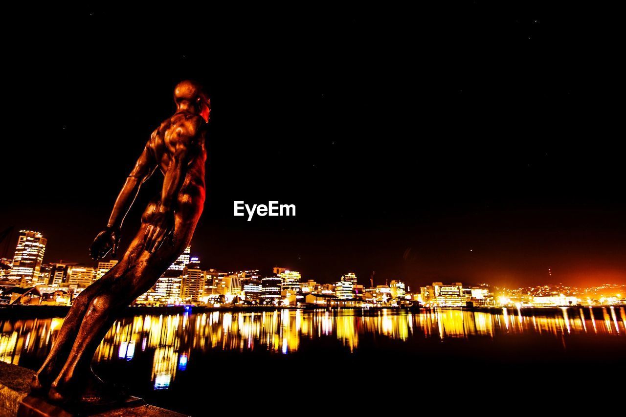 REFLECTION OF ILLUMINATED CITY IN WATER