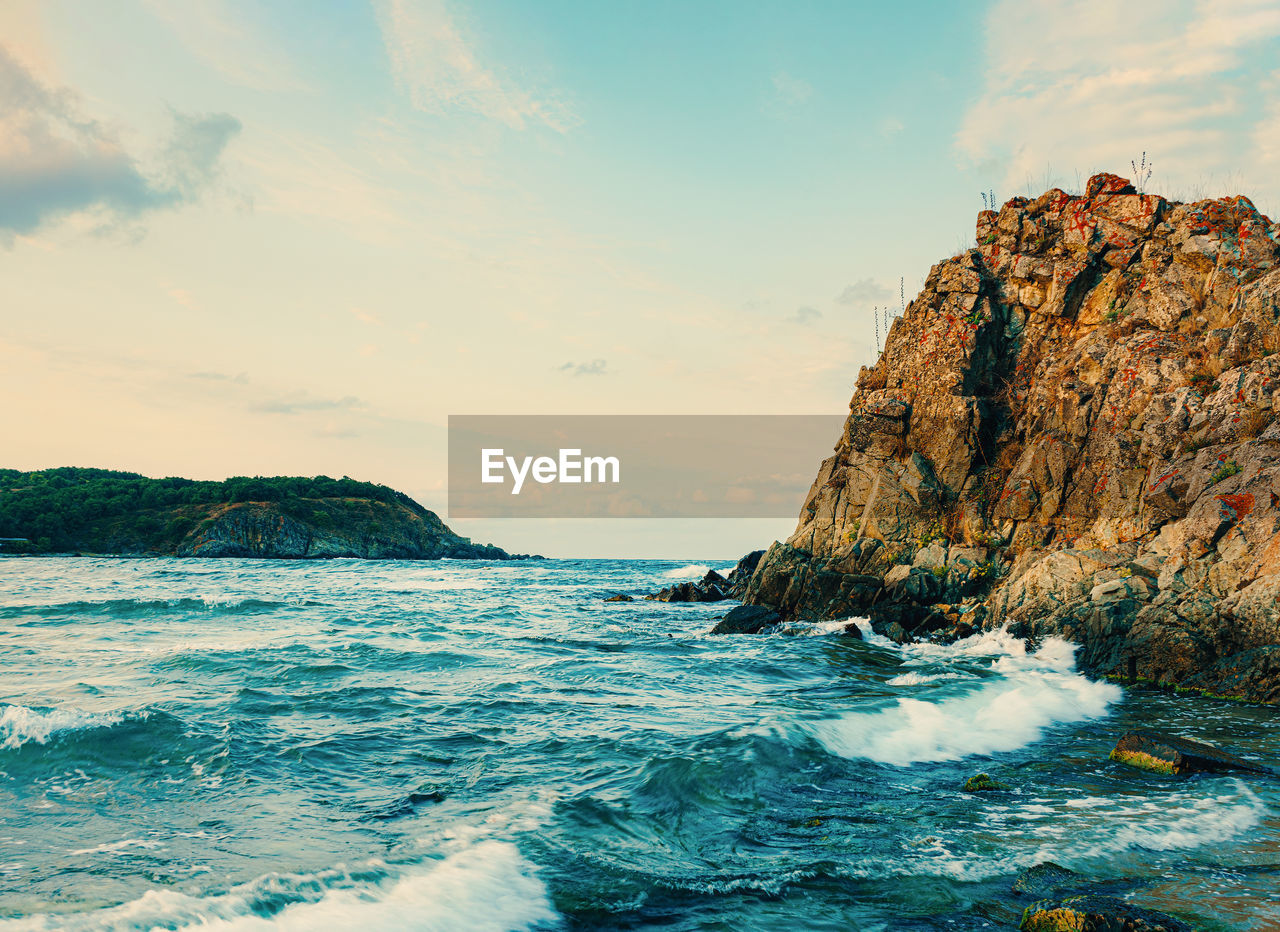 Rock formations in sea against sky