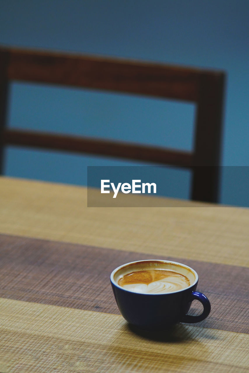 High angle view of coffee cup on wooden table