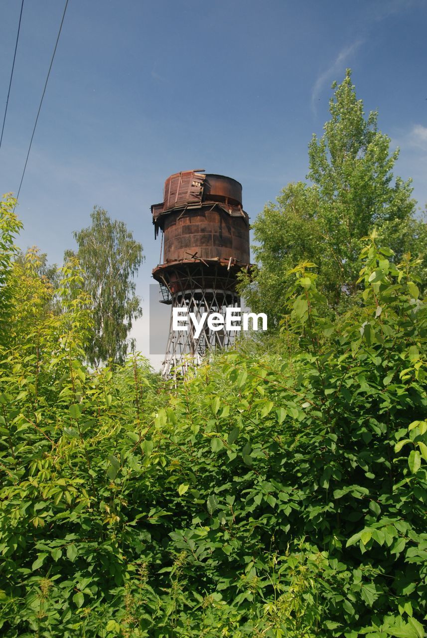 LOW ANGLE VIEW OF WATER TOWER AMIDST TREES AGAINST SKY