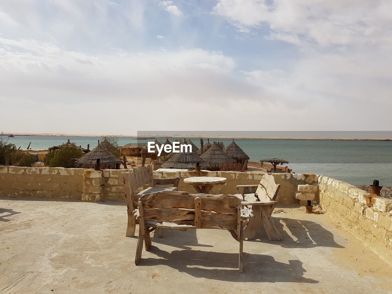 Chairs on table by sea against sky in siwa egypt