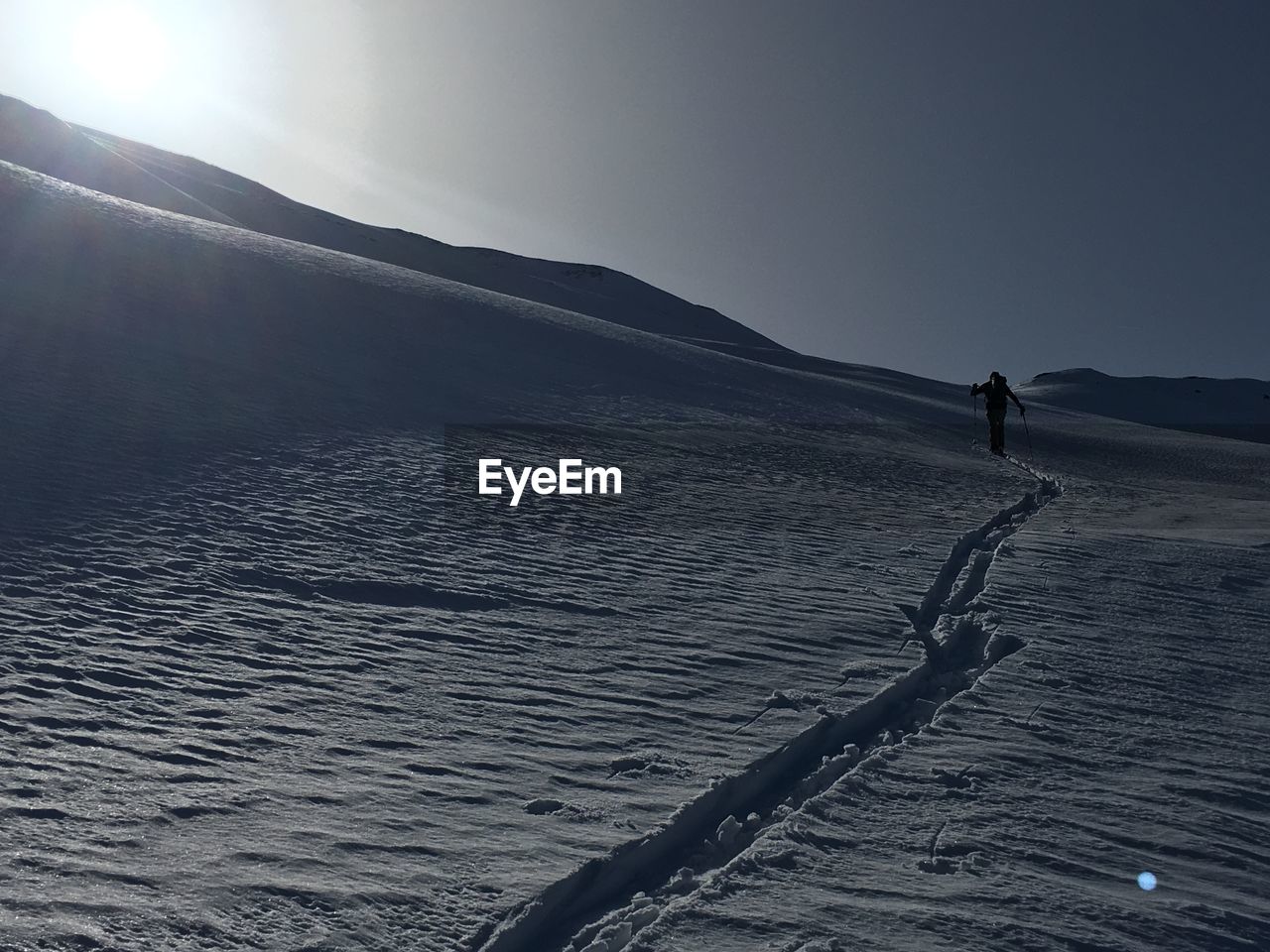 MAN SKIING ON LAND AGAINST SKY