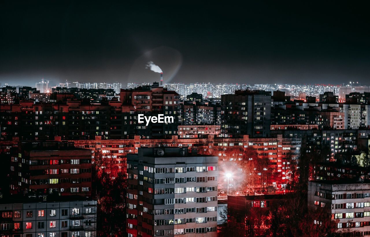 Illuminated cityscape against sky at night