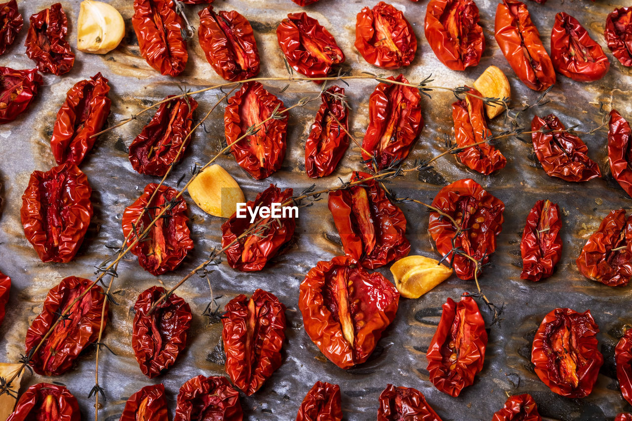 Close-up top view oven-roasted sundried tomatoes on a baking sheet on parchment paper 