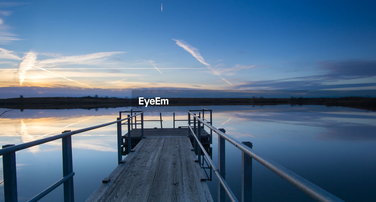 Jetty in lake against sky