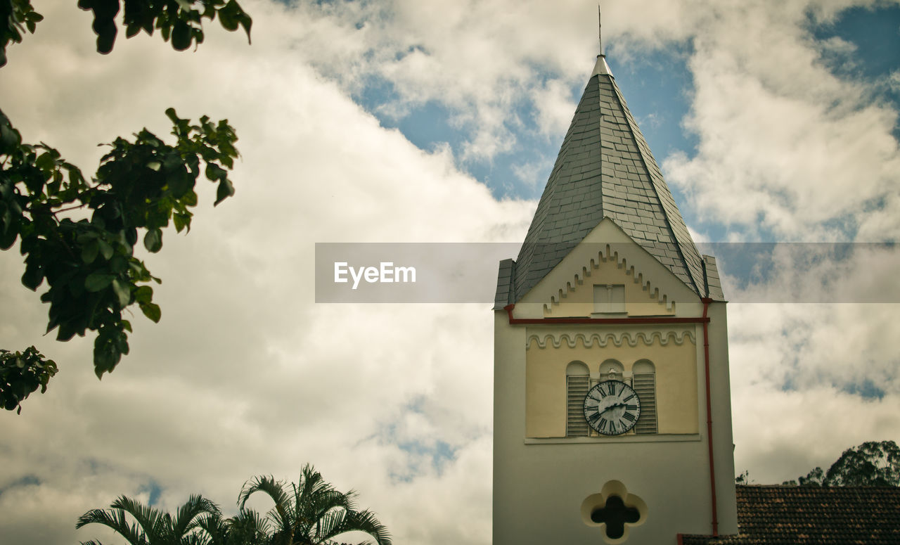 LOW ANGLE VIEW OF BUILDING AGAINST CLOUDS