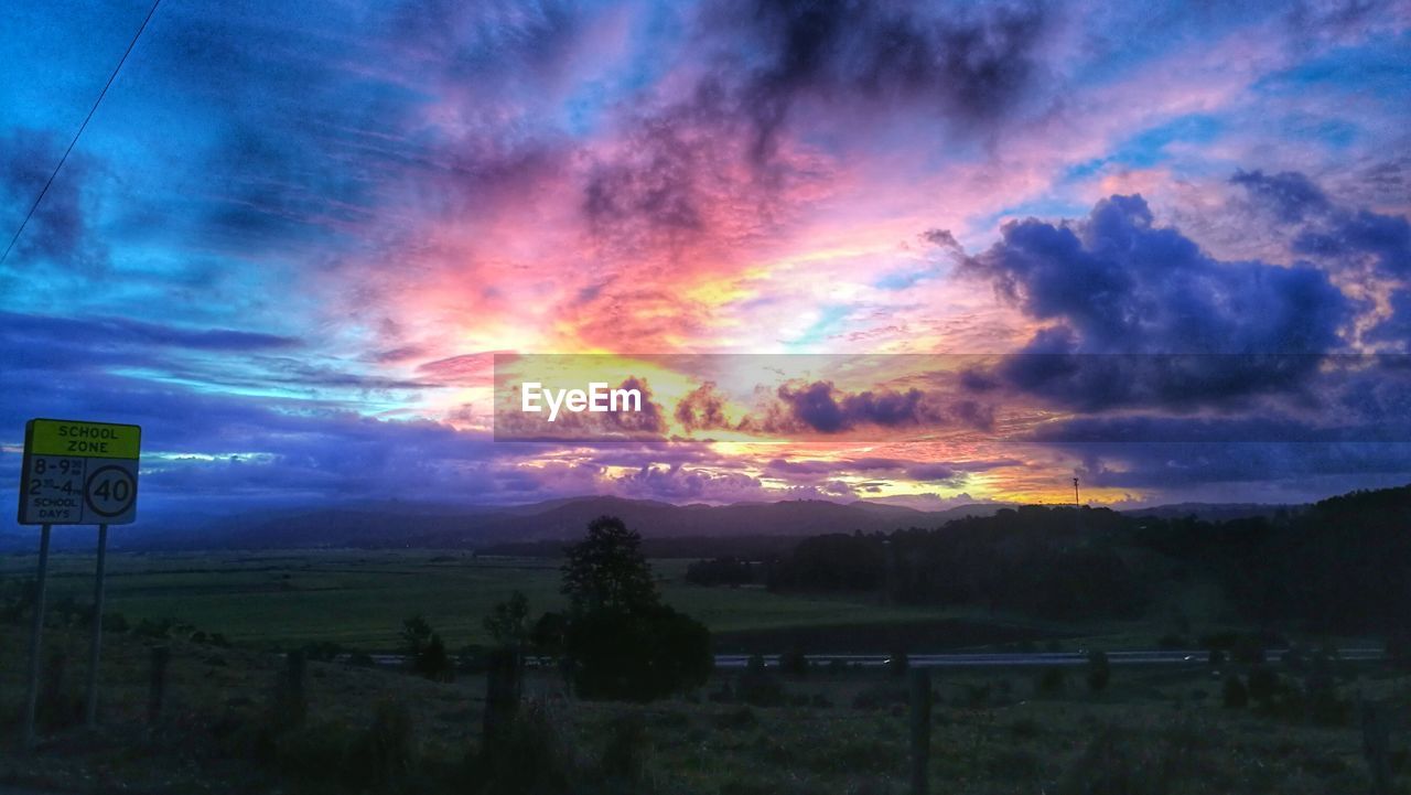 SCENIC VIEW OF LANDSCAPE AGAINST CLOUDY SKY AT SUNSET