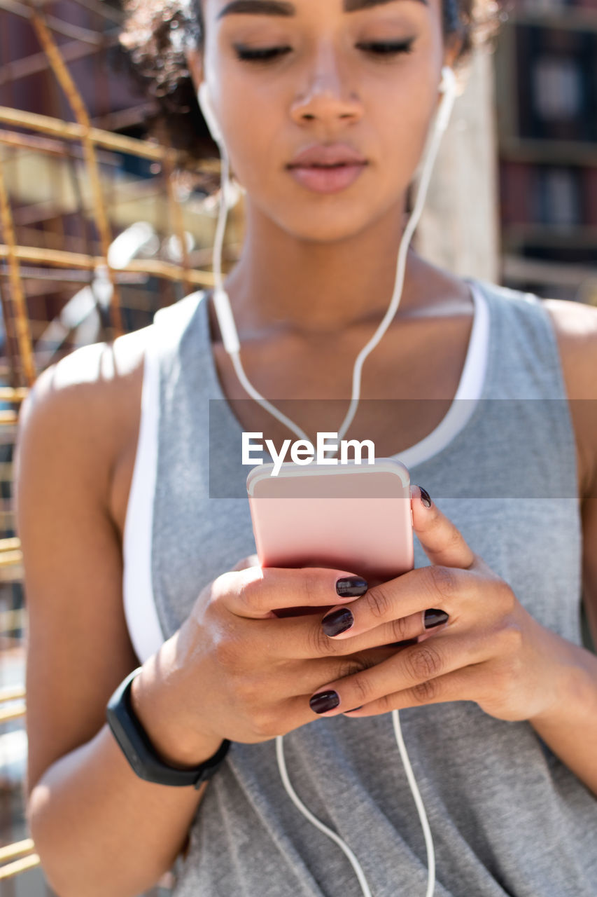 Close-up of woman using mobile phone in city