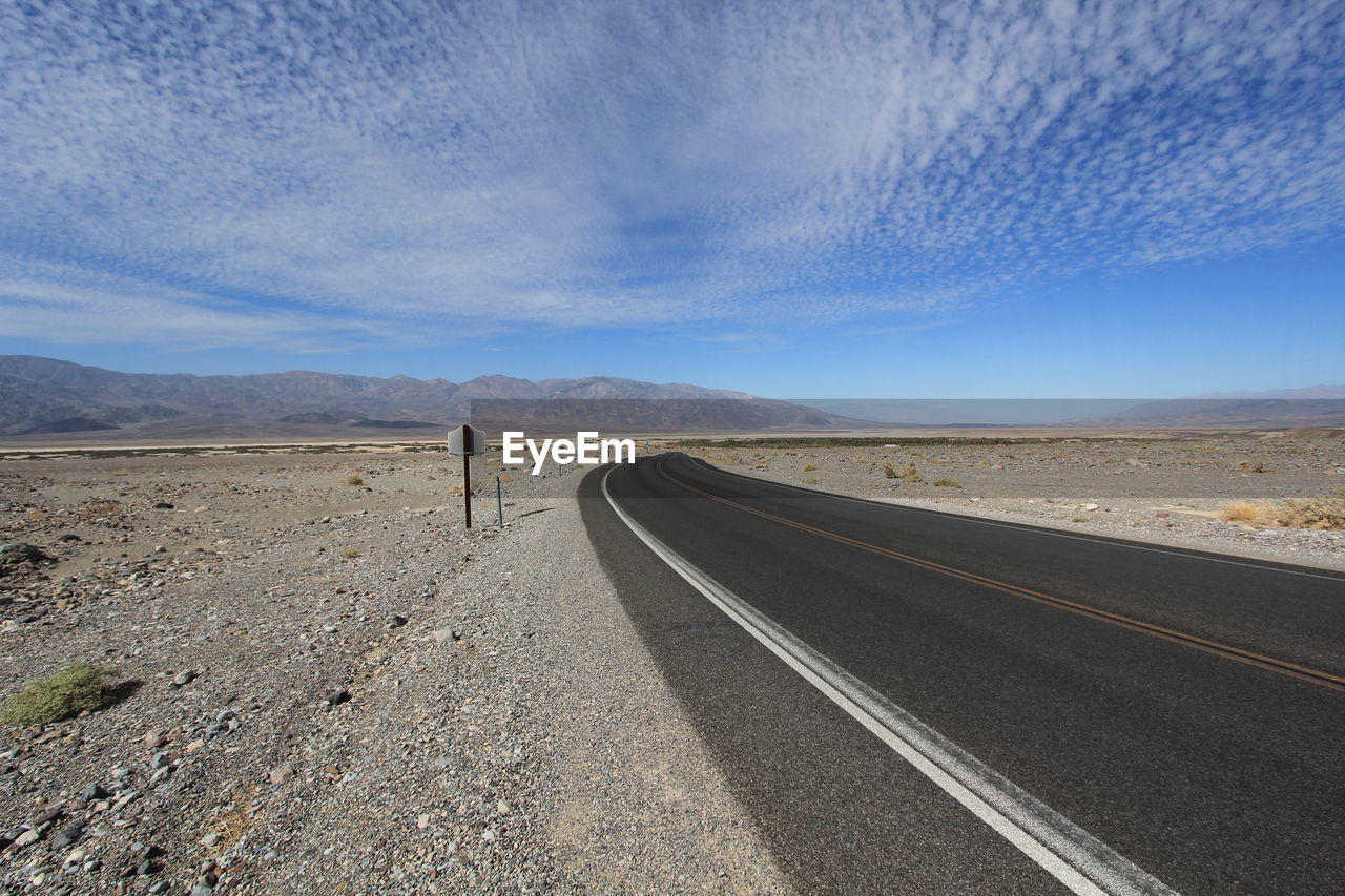 Empty road against cloudy sky