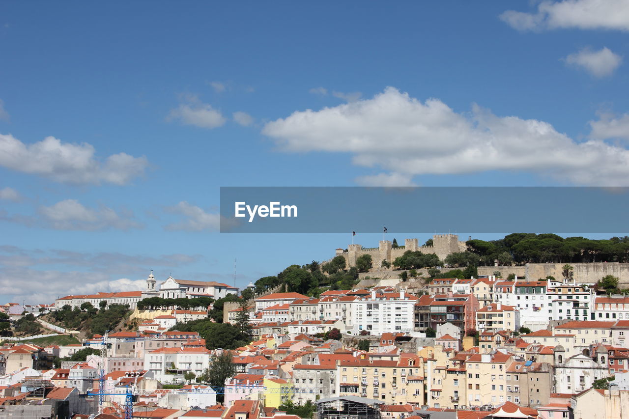 Castelo sao jorge and residential district against blue sky