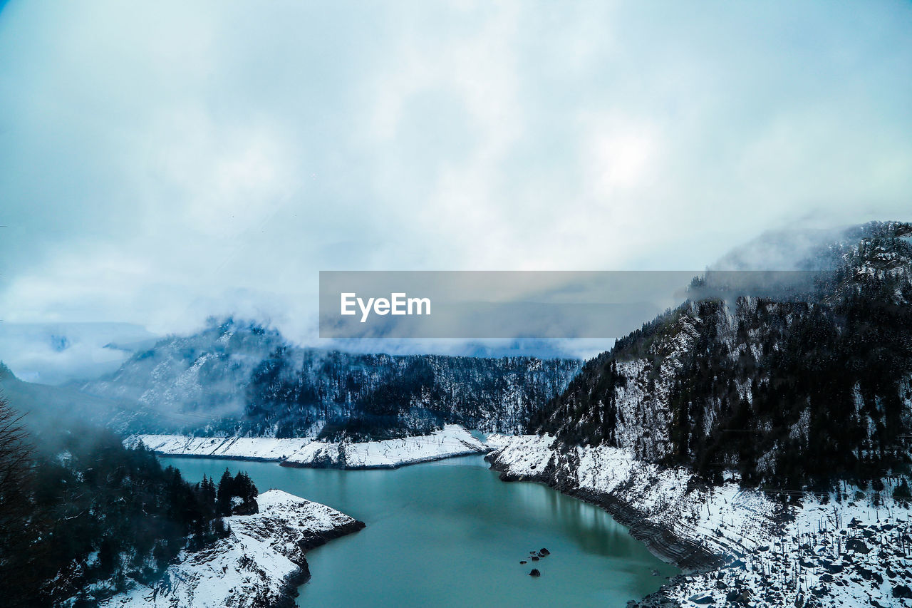 Scenic view of lake against sky during winter