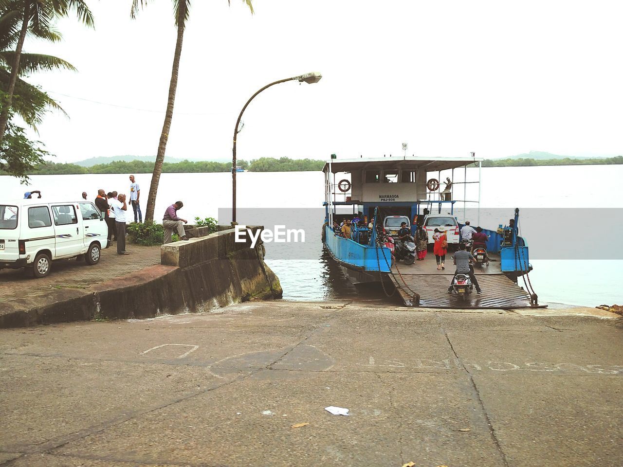 People on ferry boat against sky