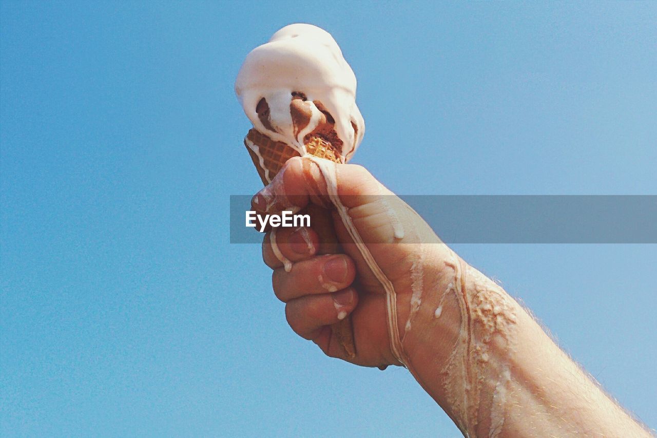 Person holding melting ice cream