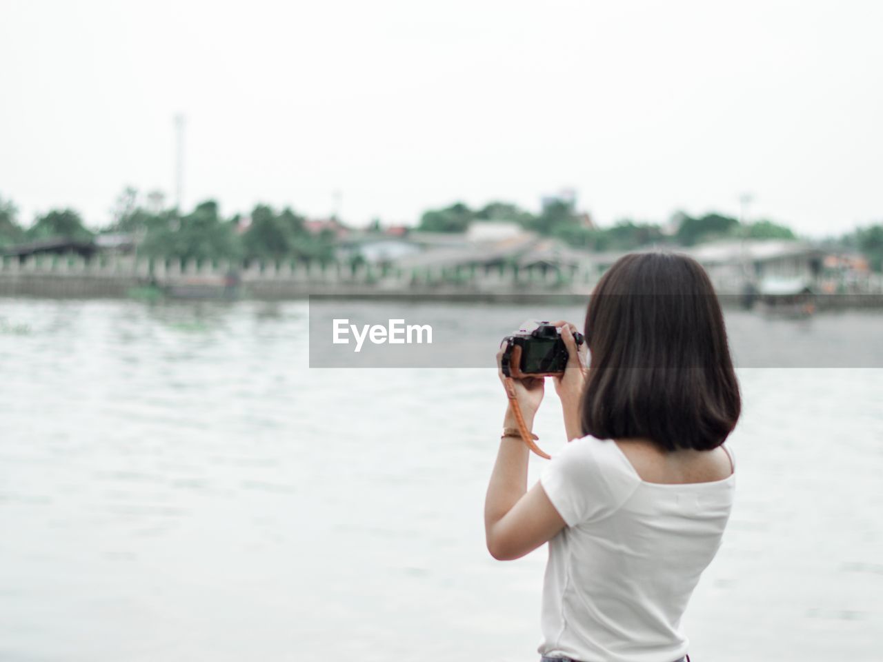 Rear view of woman photographing at camera