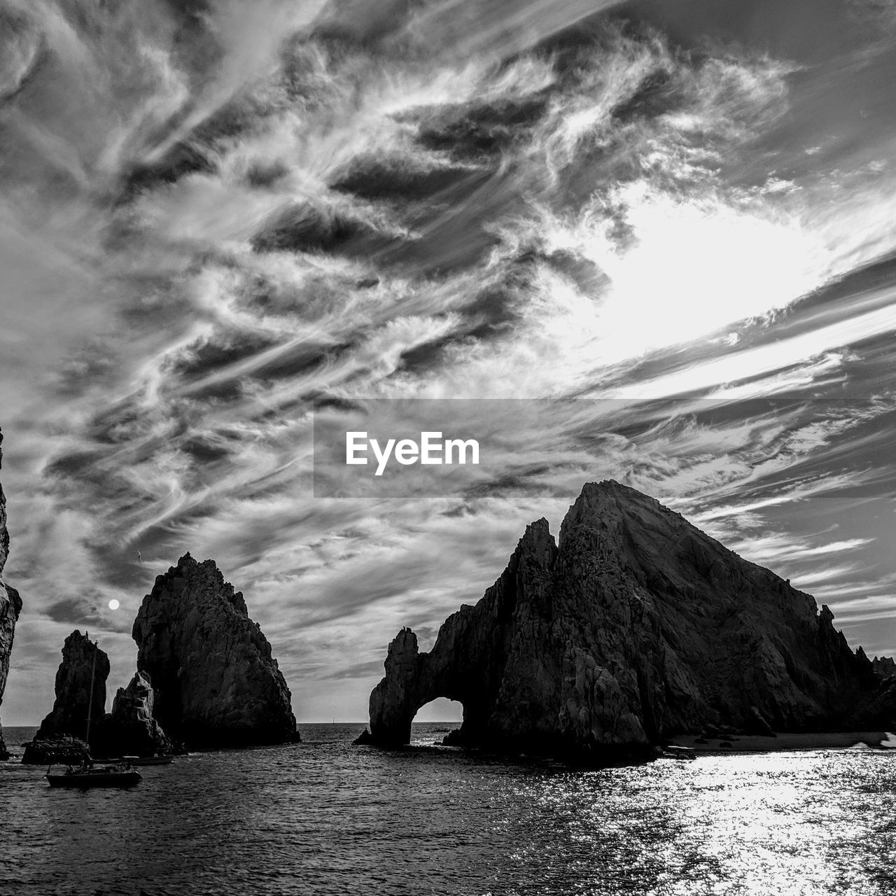 Panoramic view of rocks by sea against sky