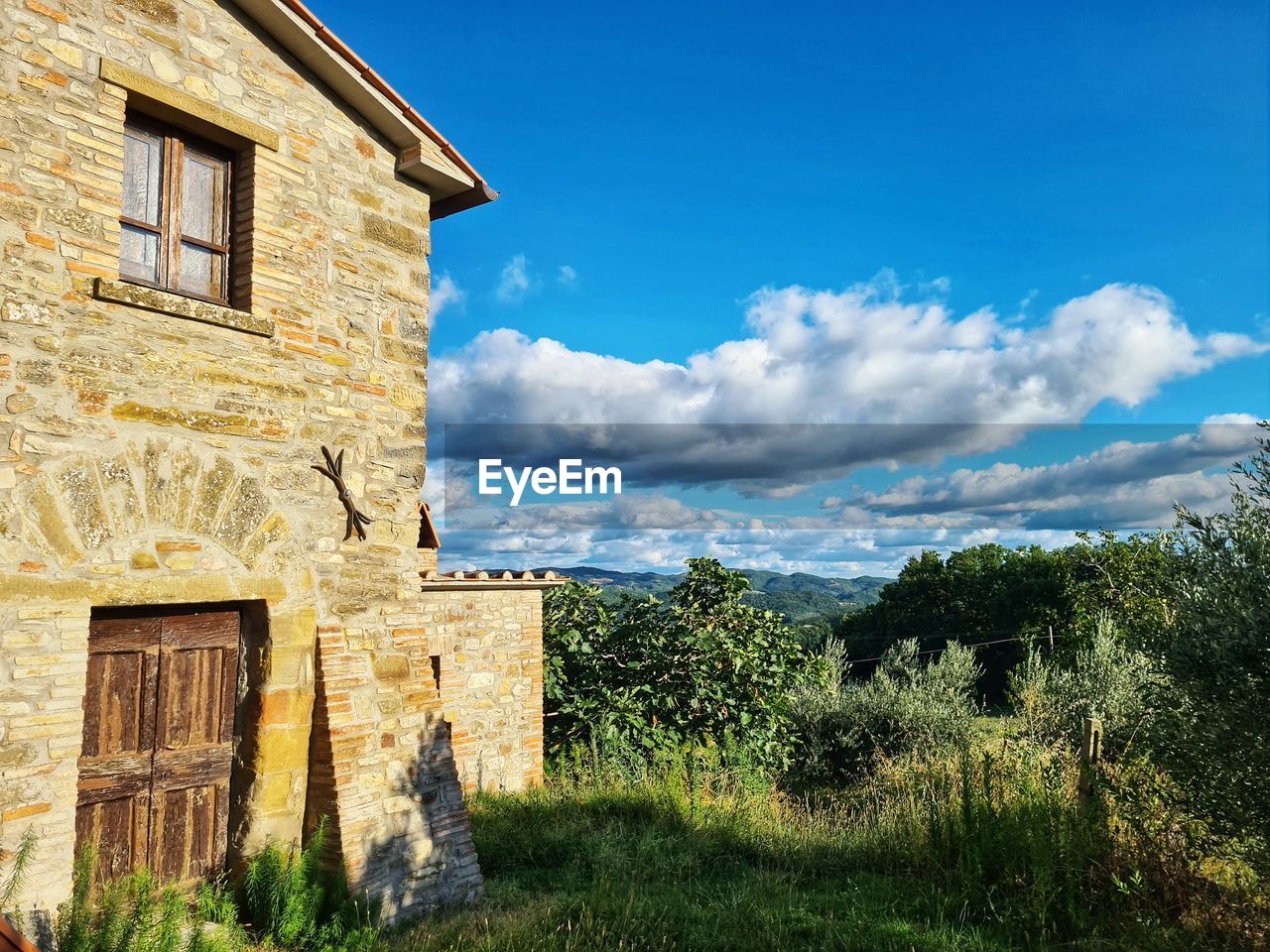 Low angle view of abandoned house on field against sky