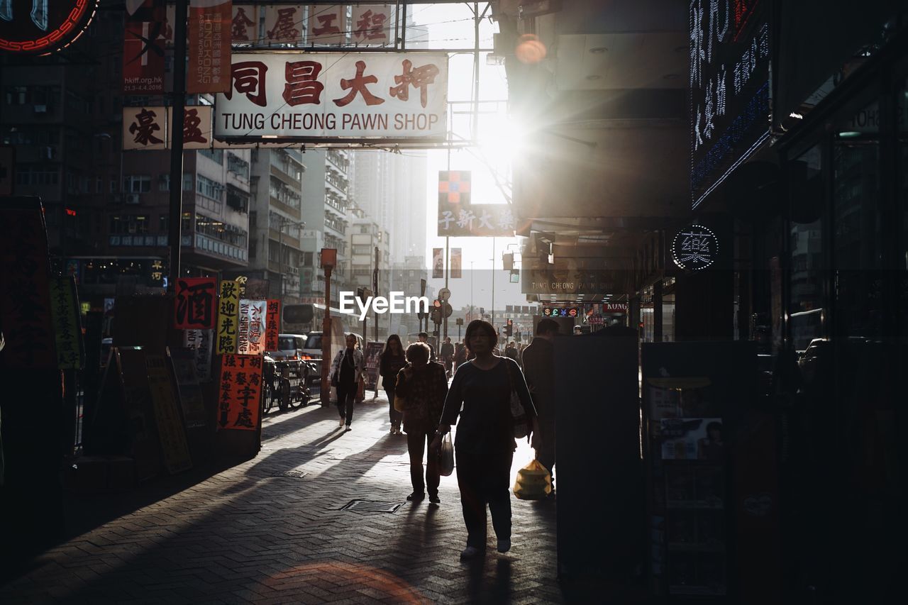 PEOPLE IN ILLUMINATED CITY AT NIGHT