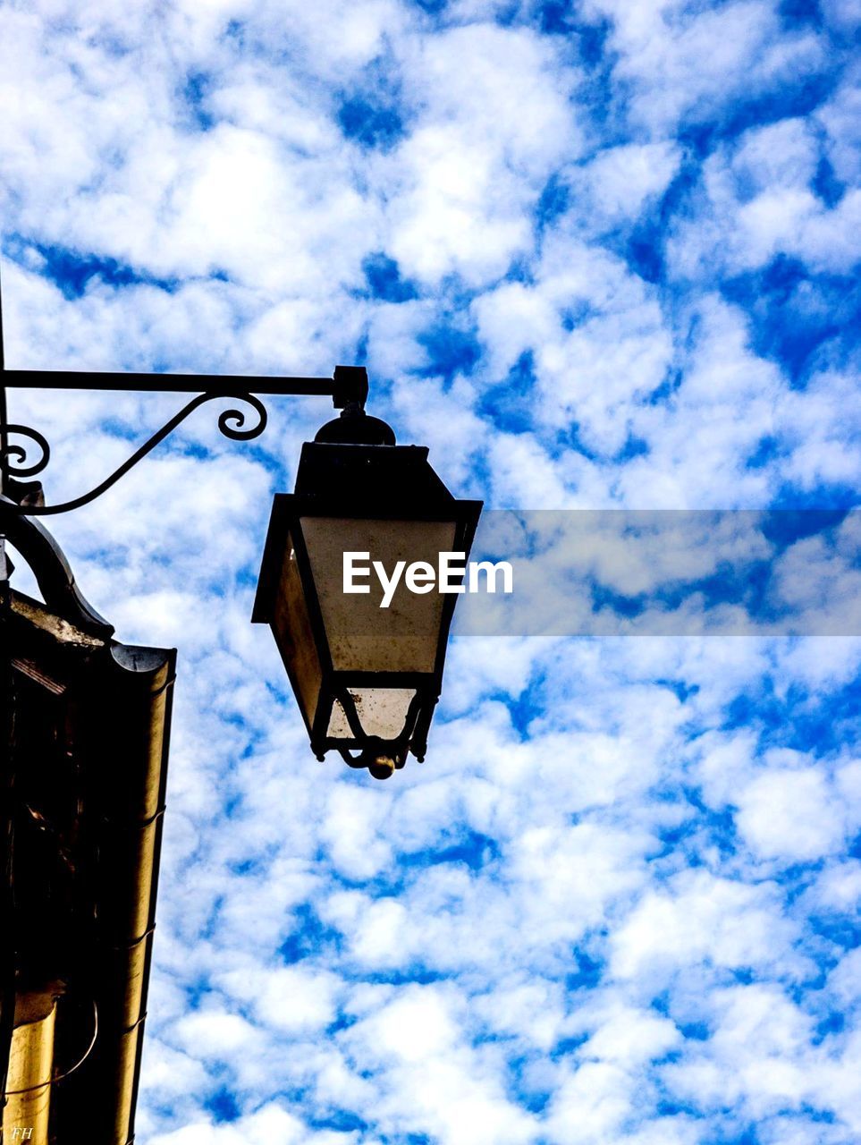 LOW ANGLE VIEW OF STREET LIGHTS AGAINST CLOUDY SKY