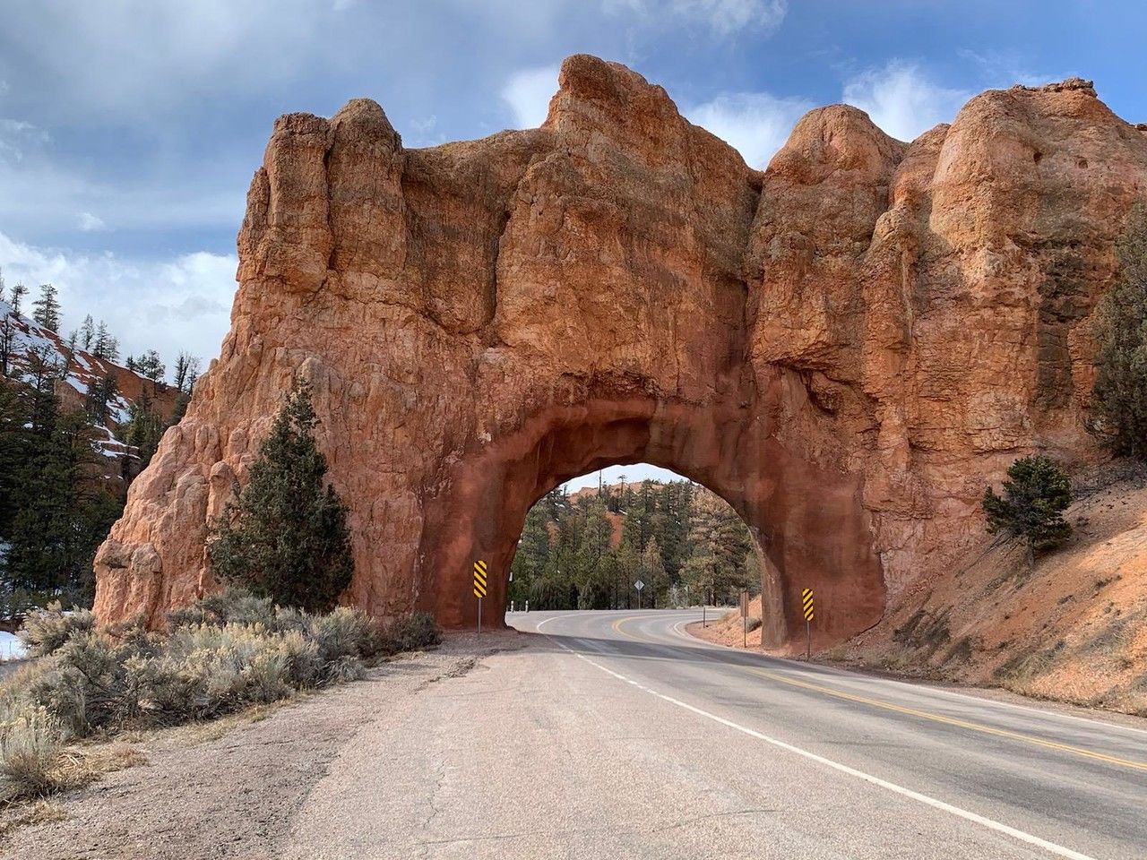 rock, road, rock formation, arch, sky, nature, landscape, scenics - nature, environment, travel destinations, cloud, transportation, land, travel, beauty in nature, no people, non-urban scene, plant, tree, desert, valley, natural arch, geology, the way forward, architecture, mountain, outdoors, tranquility, eroded, physical geography, semi-arid, day, extreme terrain, tourism, canyon, street, highway, footpath
