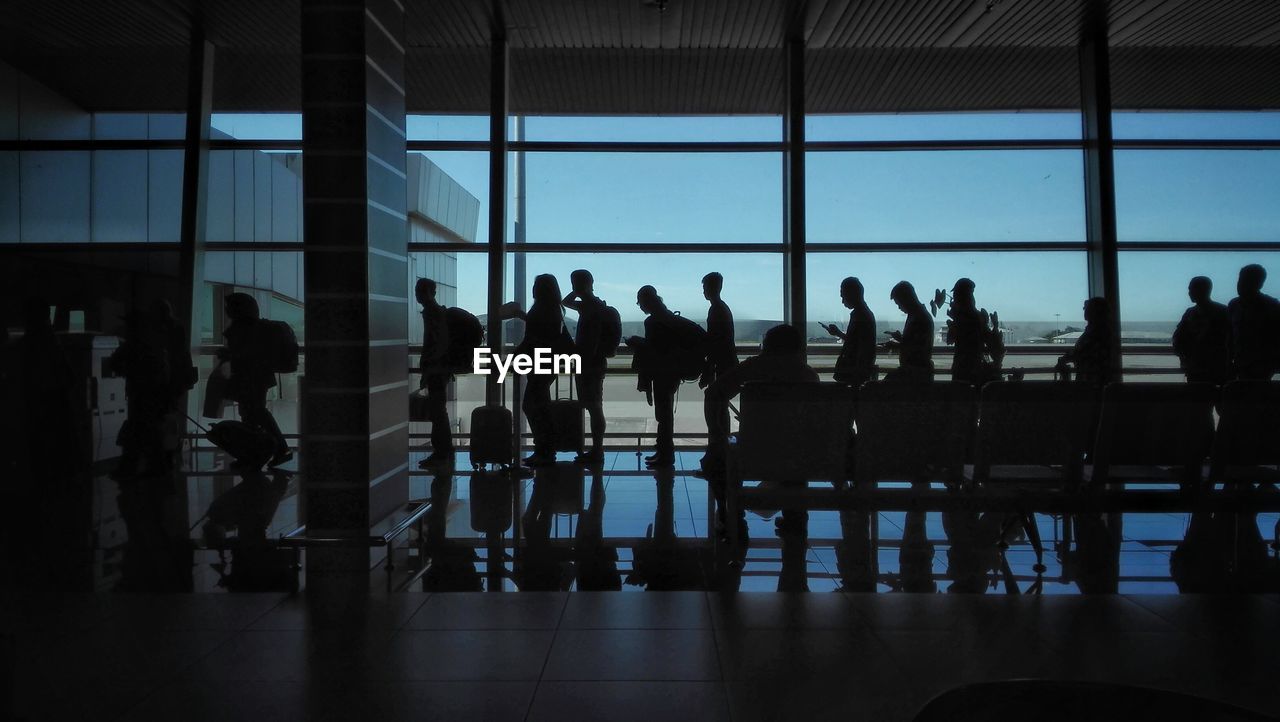 Silhouette people waiting in queue at airport