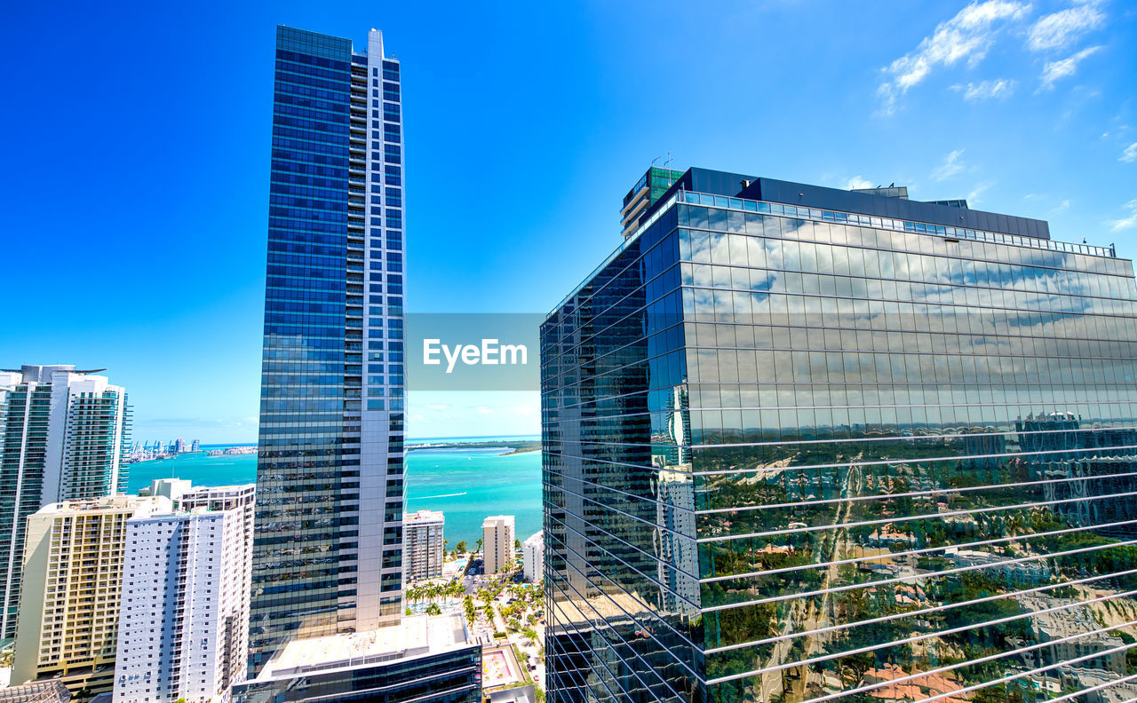 Low angle view of modern buildings against blue sky