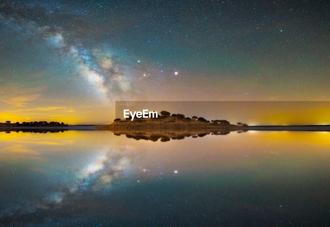 Scenic view of lake against sky at night