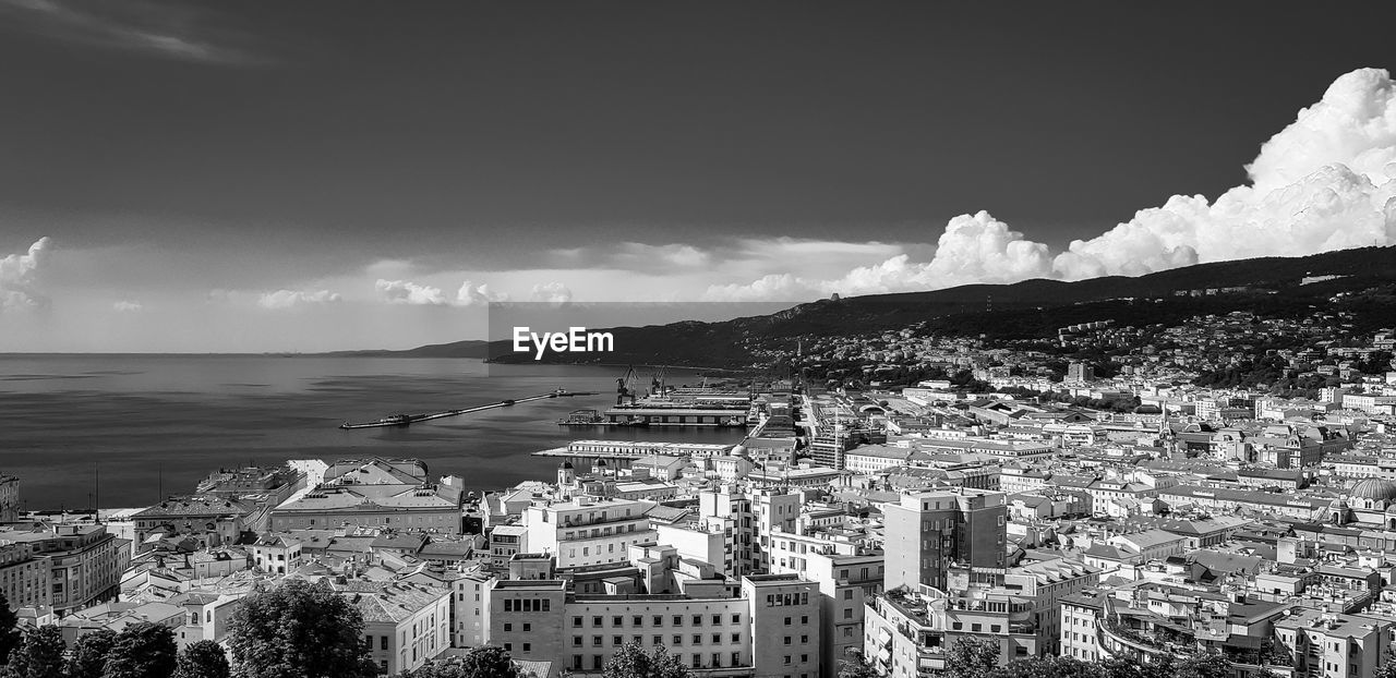 High angle view of townscape by sea against sky