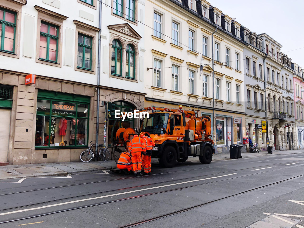 CARS ON ROAD BY BUILDING IN CITY