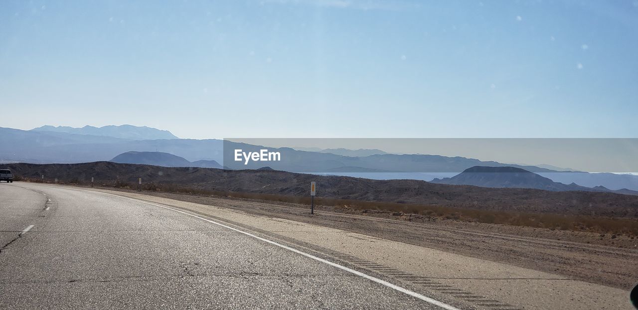 EMPTY ROAD BY MOUNTAIN AGAINST SKY