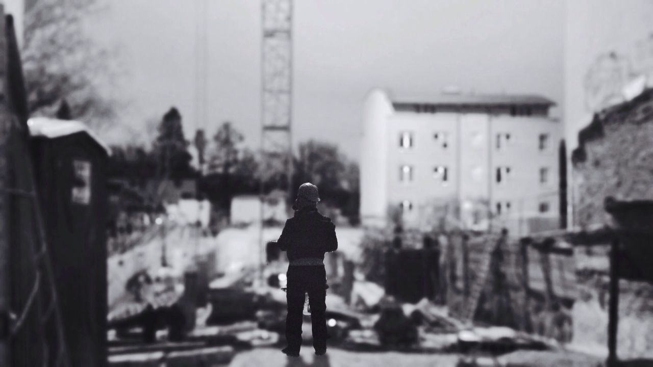 Tilt-shift image of man standing on building