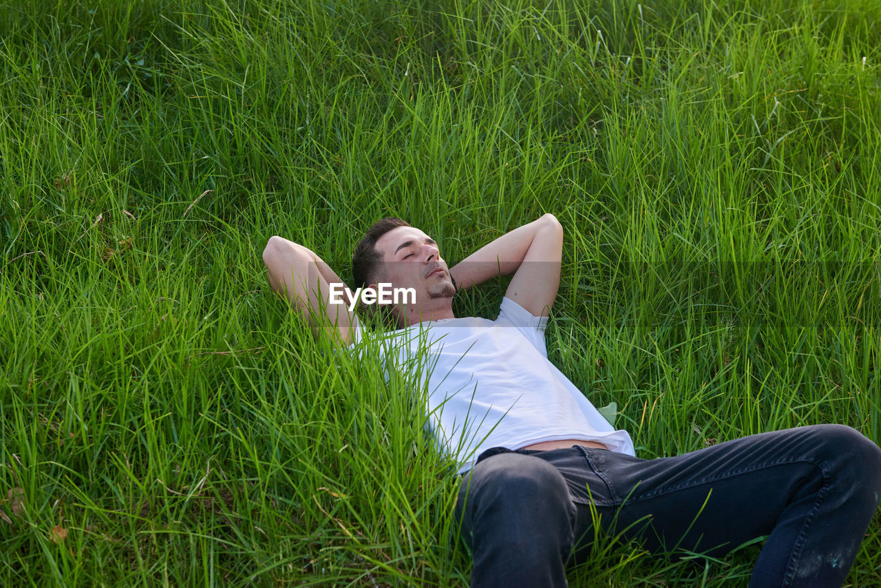 portrait of young woman sitting on grassy field