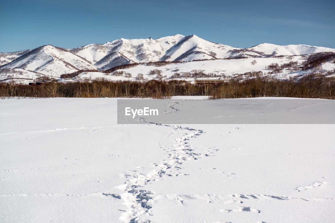 SNOW COVERED MOUNTAINS AGAINST SKY