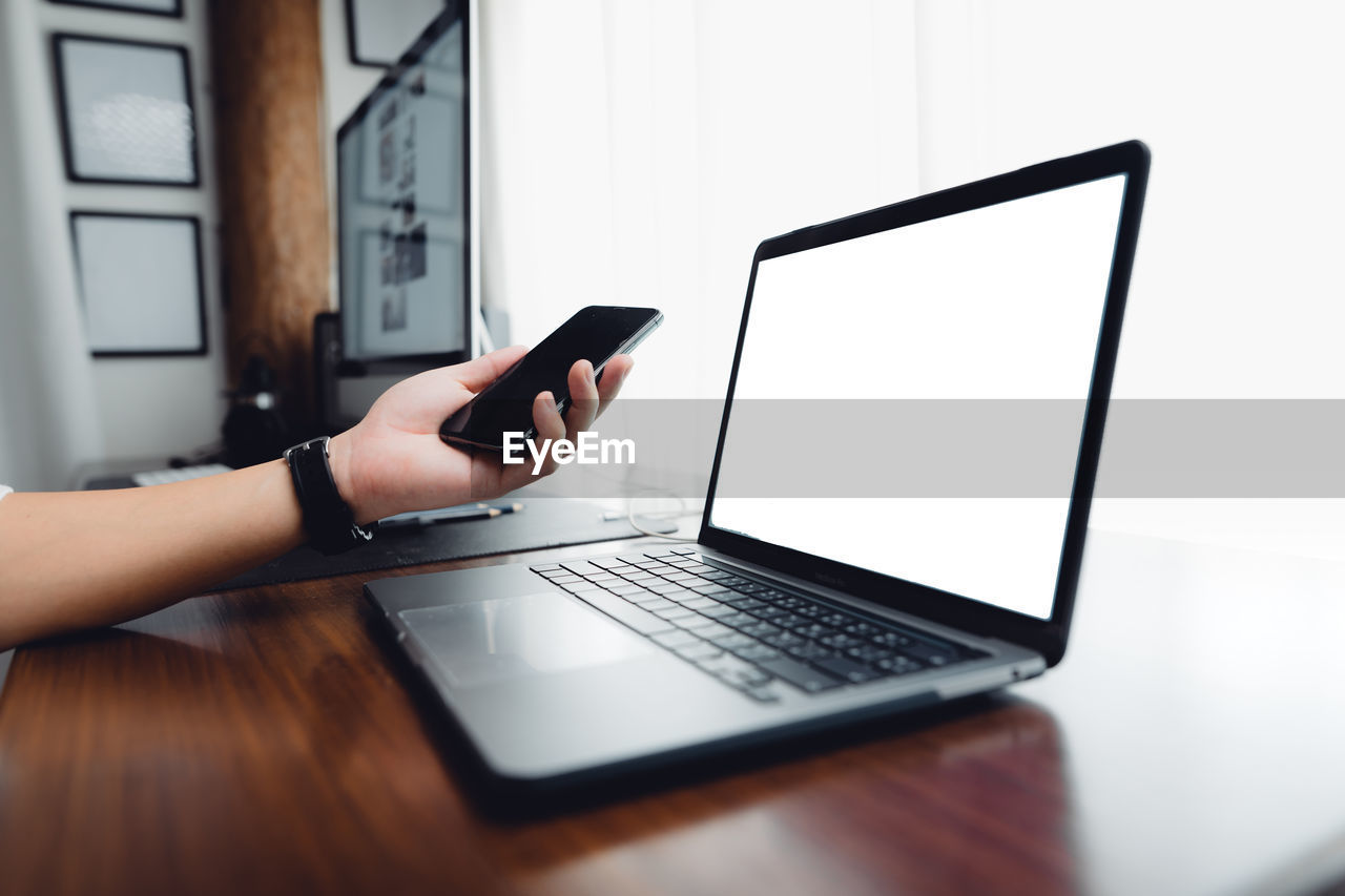 Hands working with blank screen laptop computer mock up