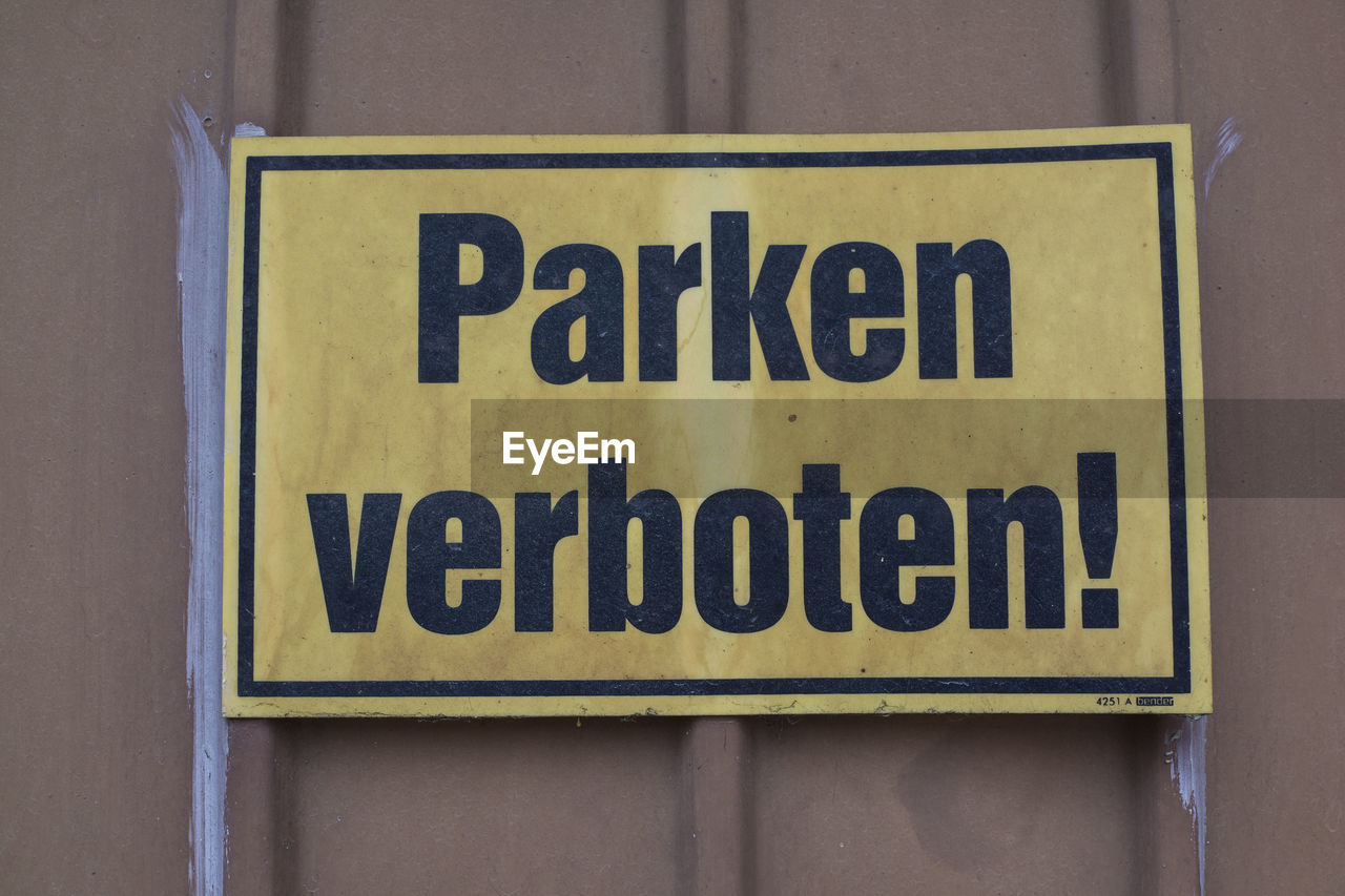 Close-up of warning sign on corrugated iron