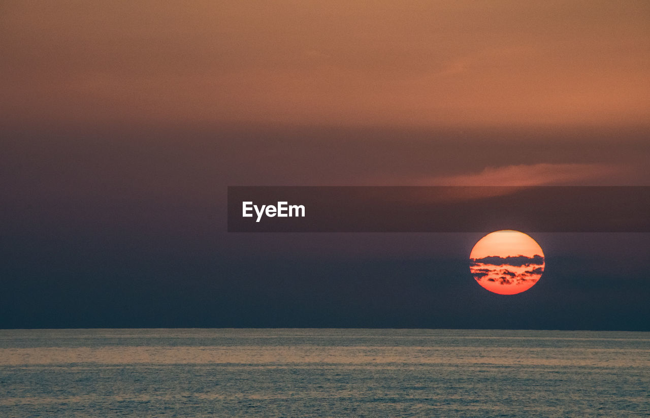 Scenic view of sea against orange sky