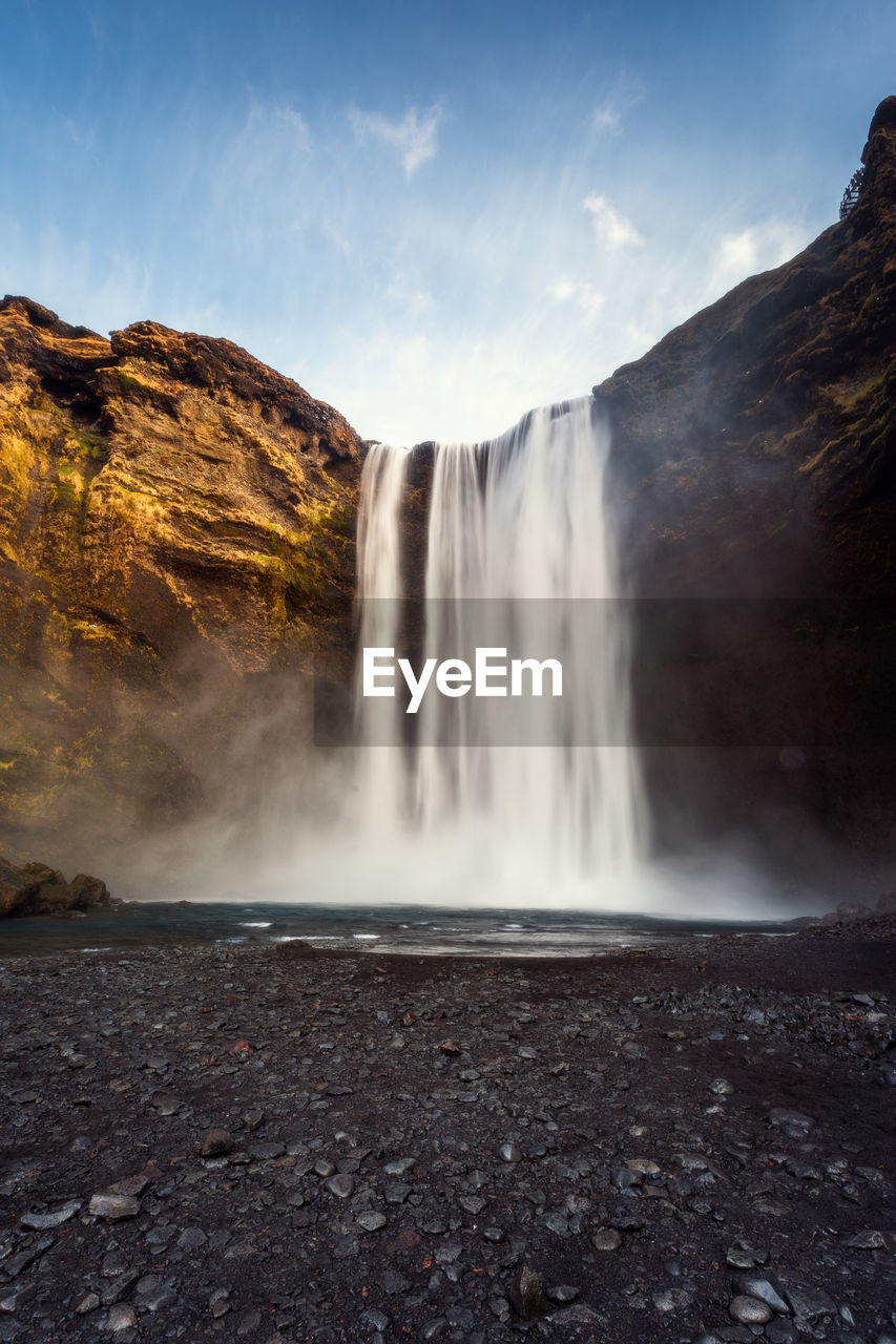 scenic view of waterfall in forest against sky