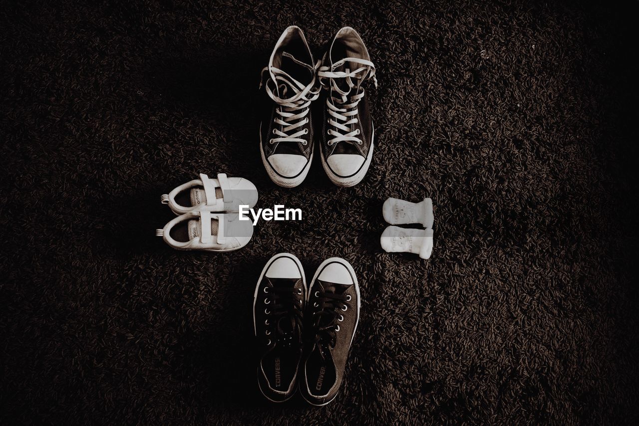 High angle view of shoes and baby booties on rug