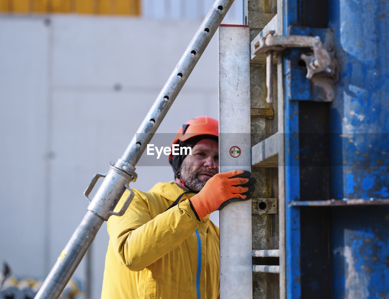 Worker measuring formwork with spirit level at construction site