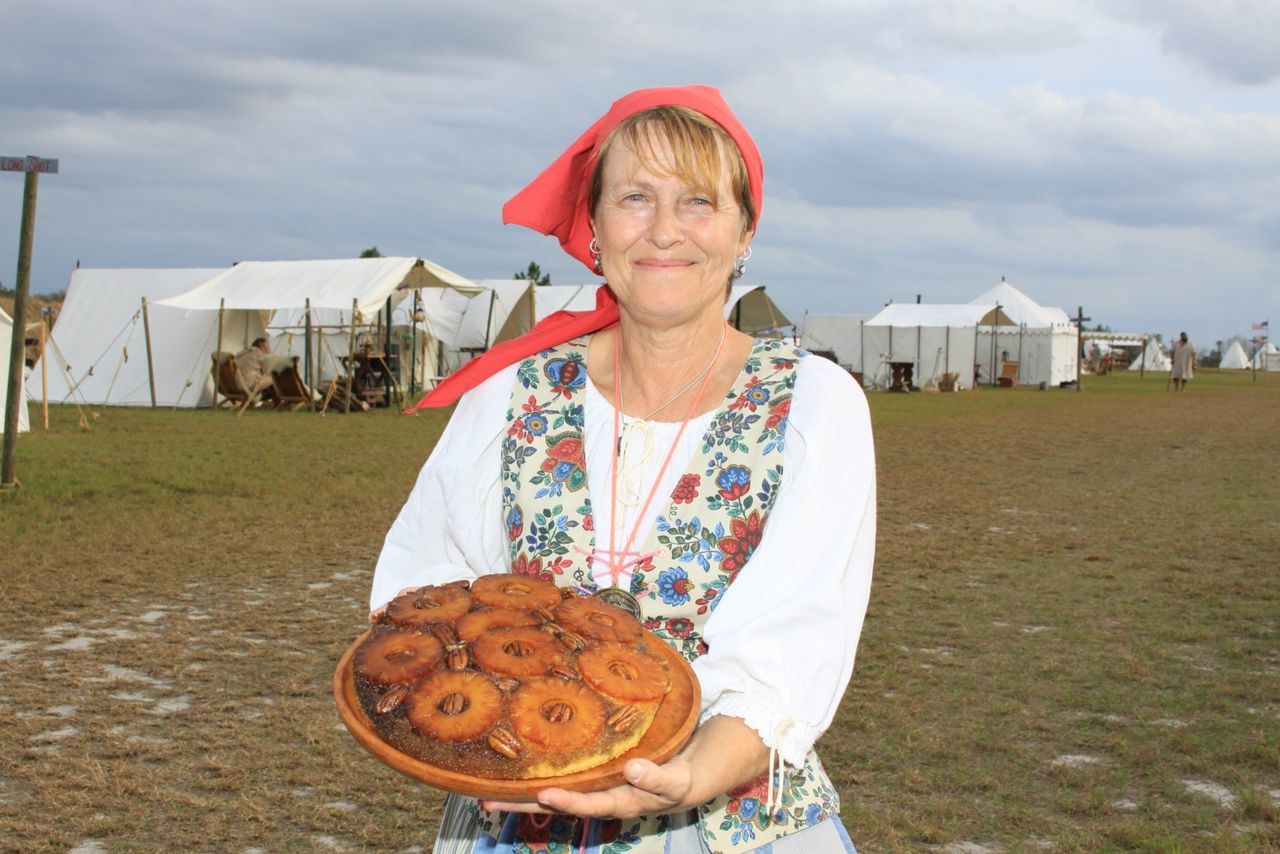 Woman wearing traditional clothing holding tray with food