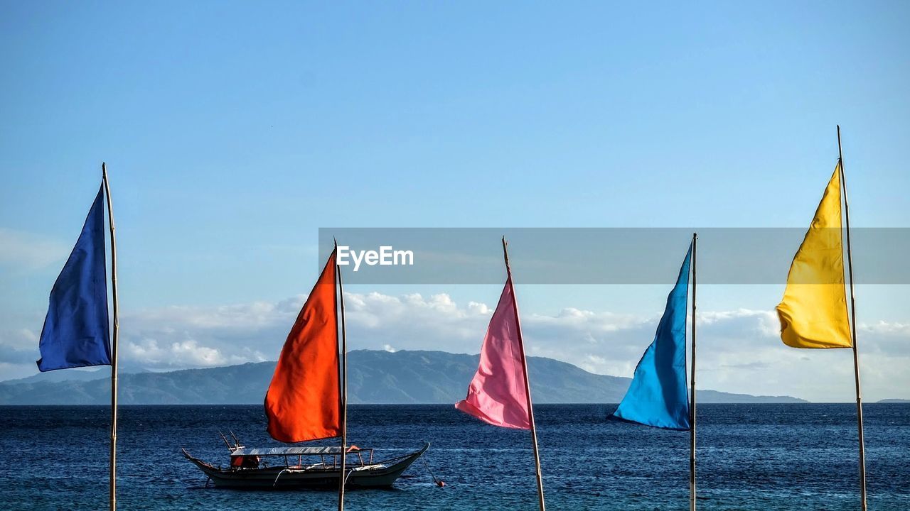 Boats in sea against blue sky