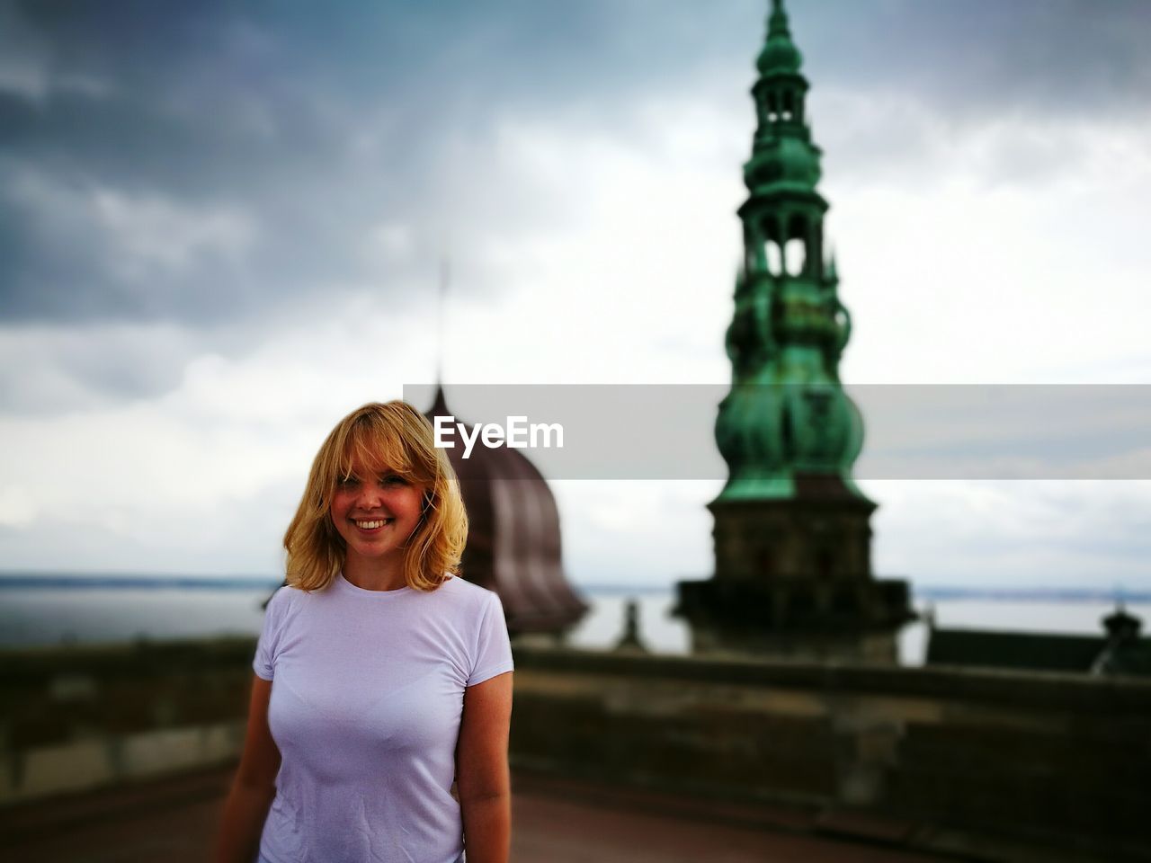 Portrait of smiling young woman standing on building terrace