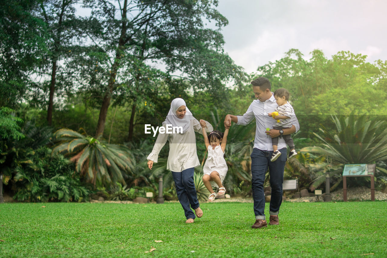 Happy family playing in public park