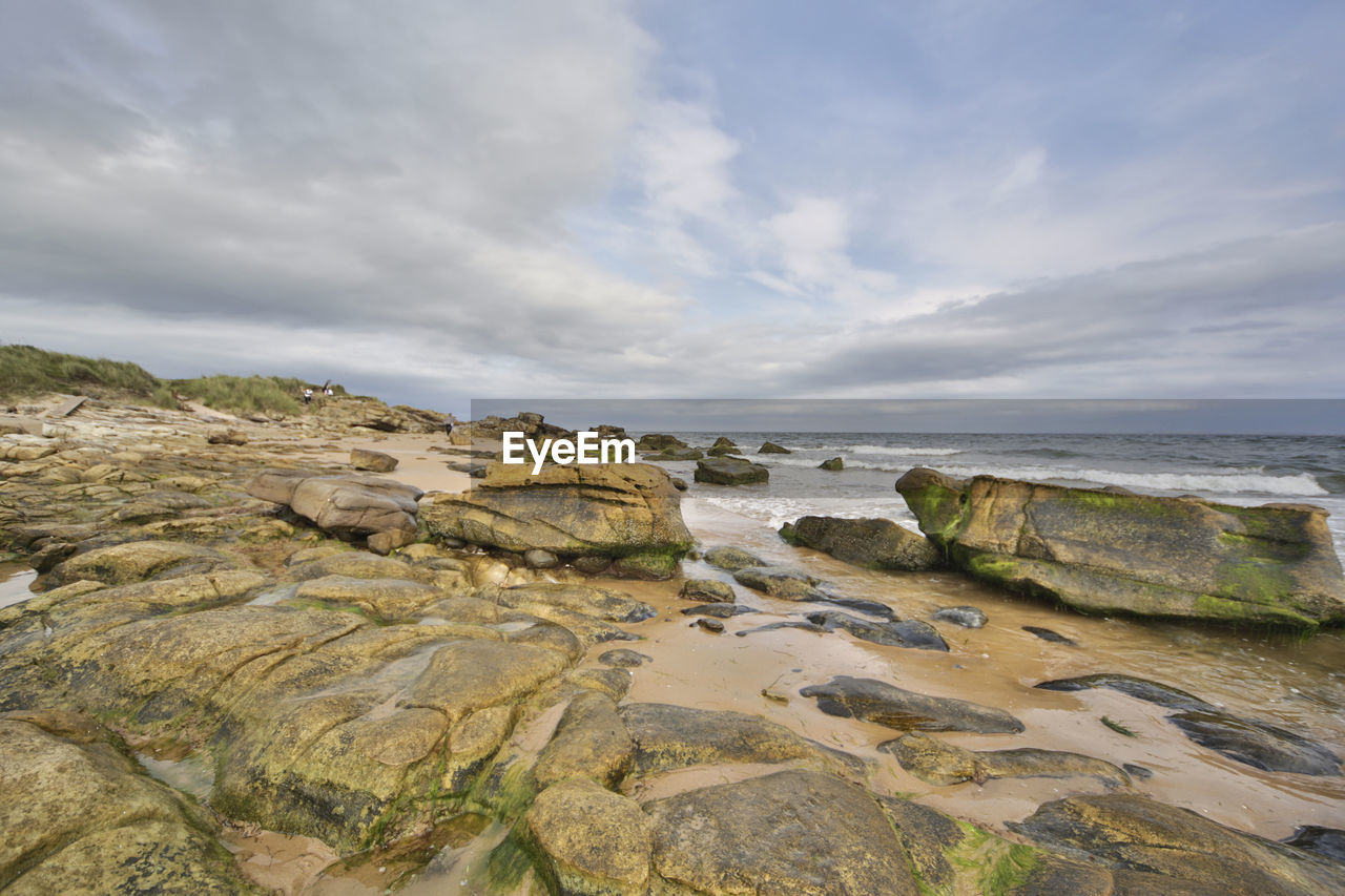 Rocks on beach against sky