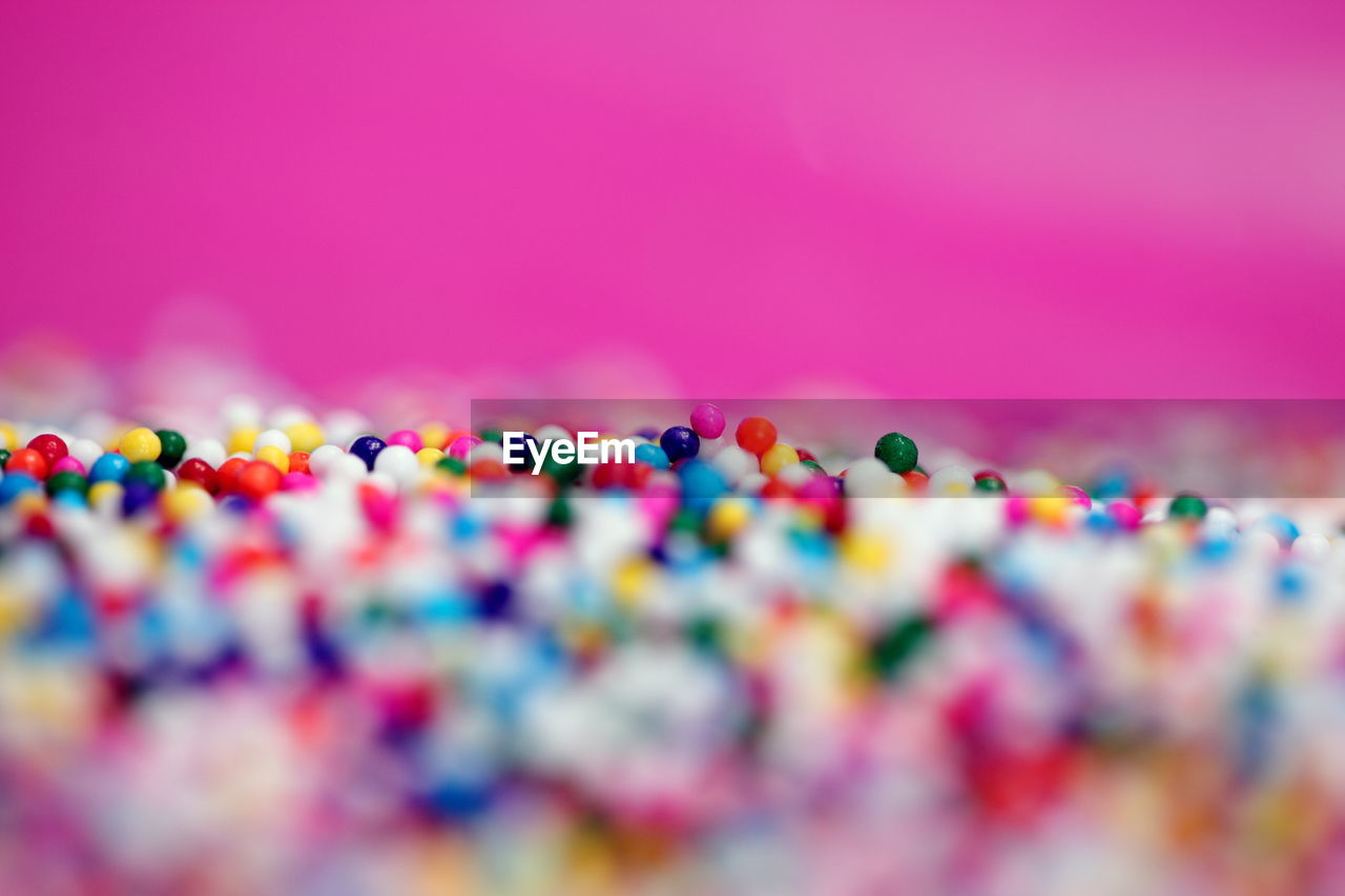 Close-up of colorful sprinkles against pink background