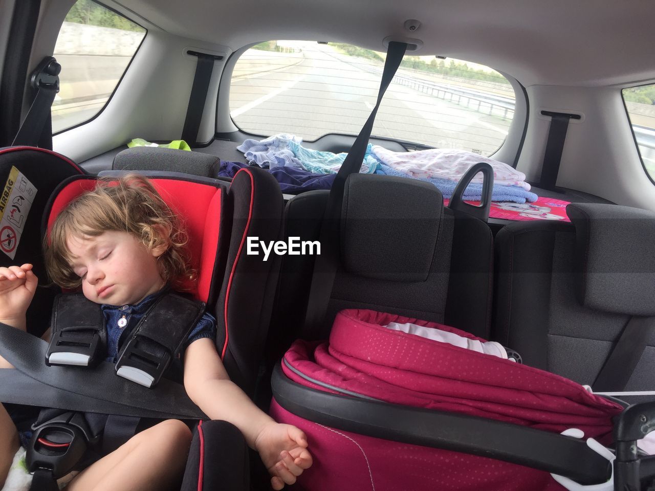 Cute girl sleeping on car during road trip